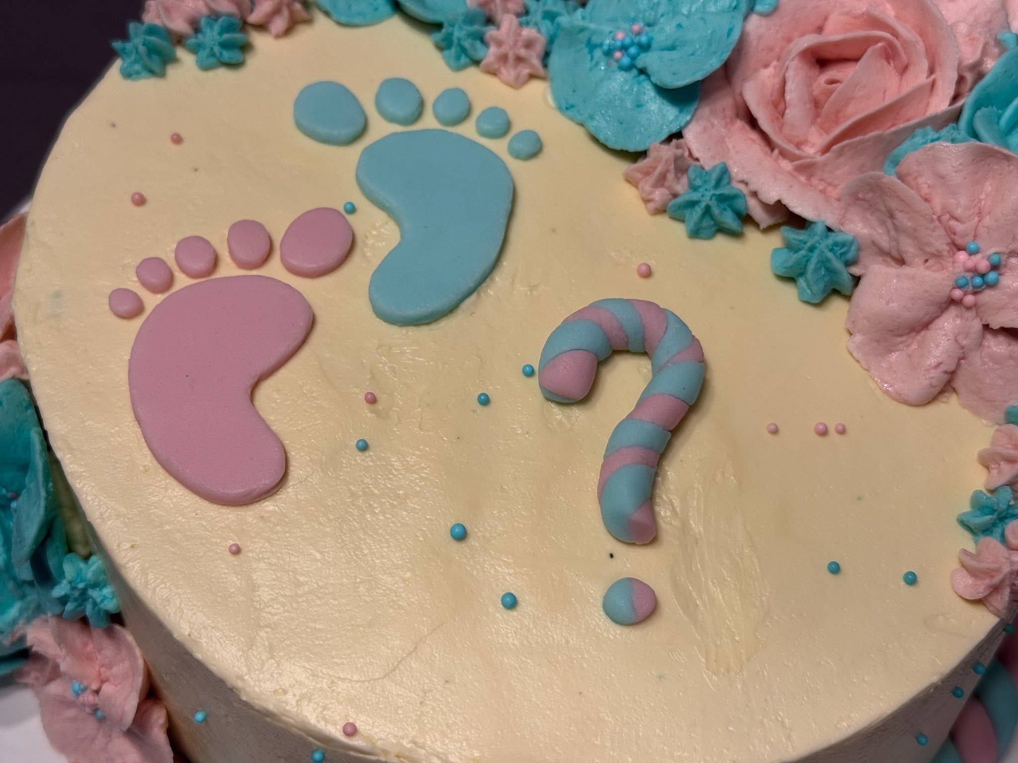 Nahaufnahme der Oberfläche mit den beiden Fußabdrücken, dem Fragezeichen und kleinen Zuckerperlen.