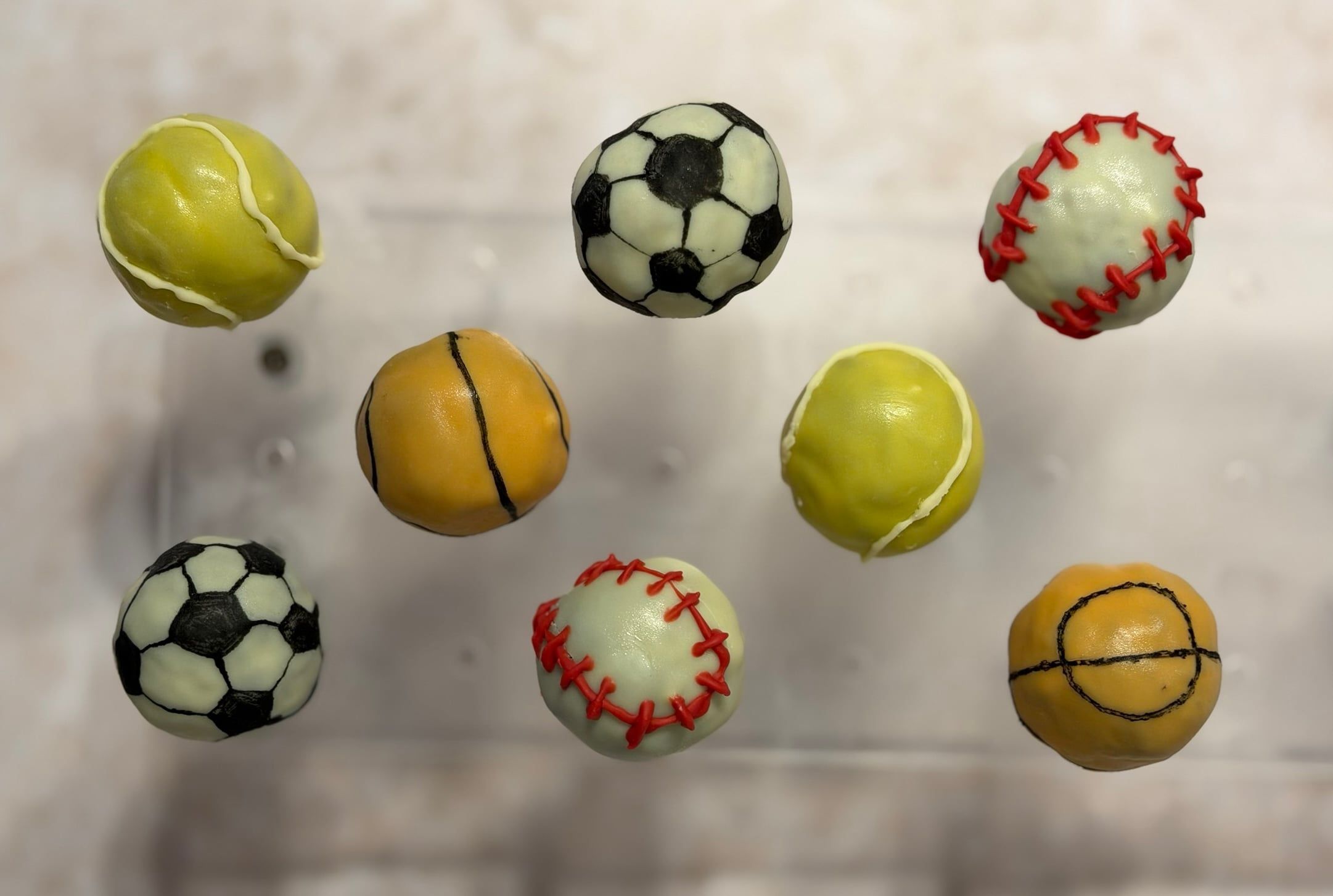 Dieselben Cake-Pops von oben, acht Bälle in zwei Reihen.